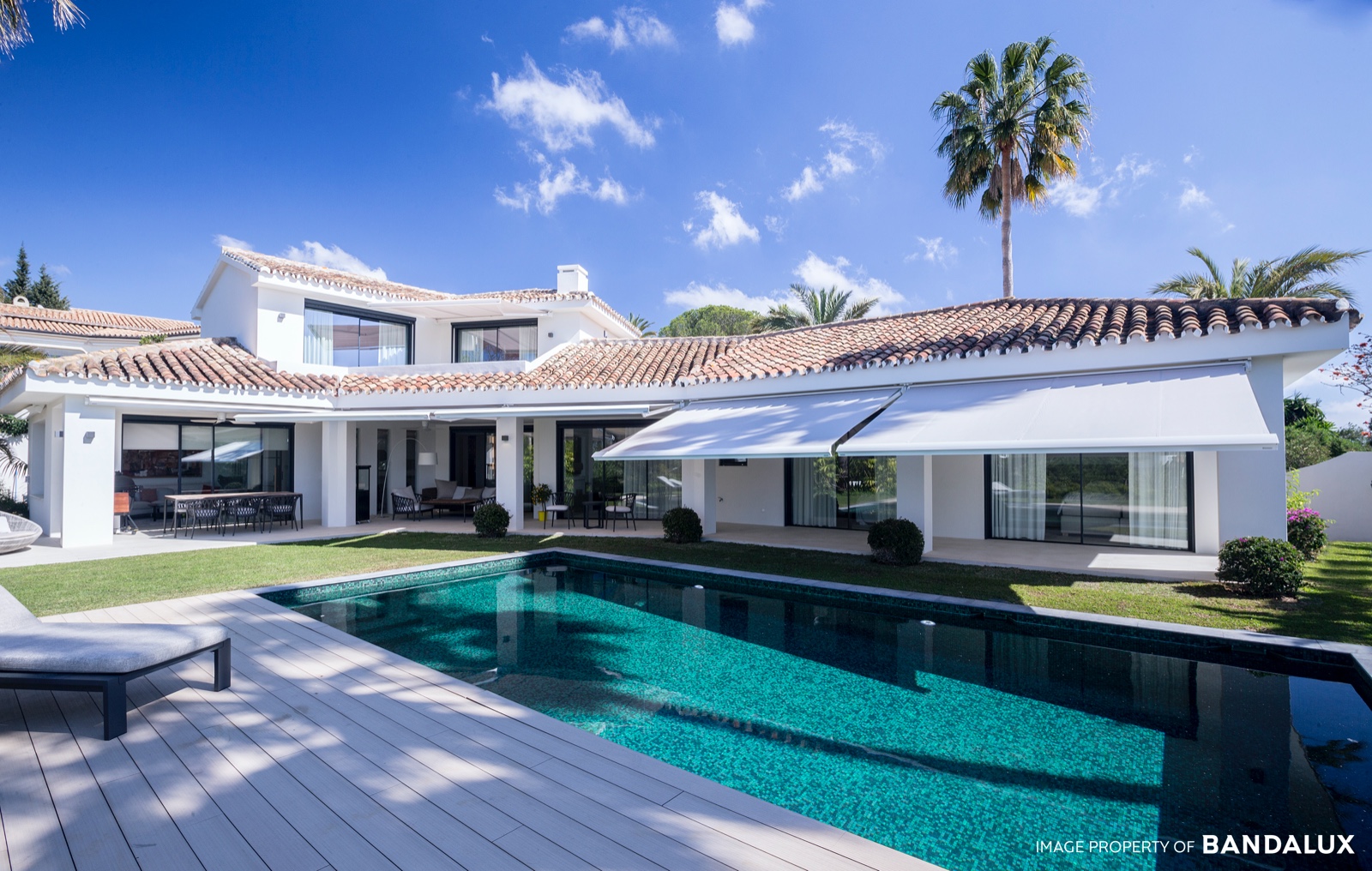 Toldos cofre blancos extendidos sobre villa con piscina