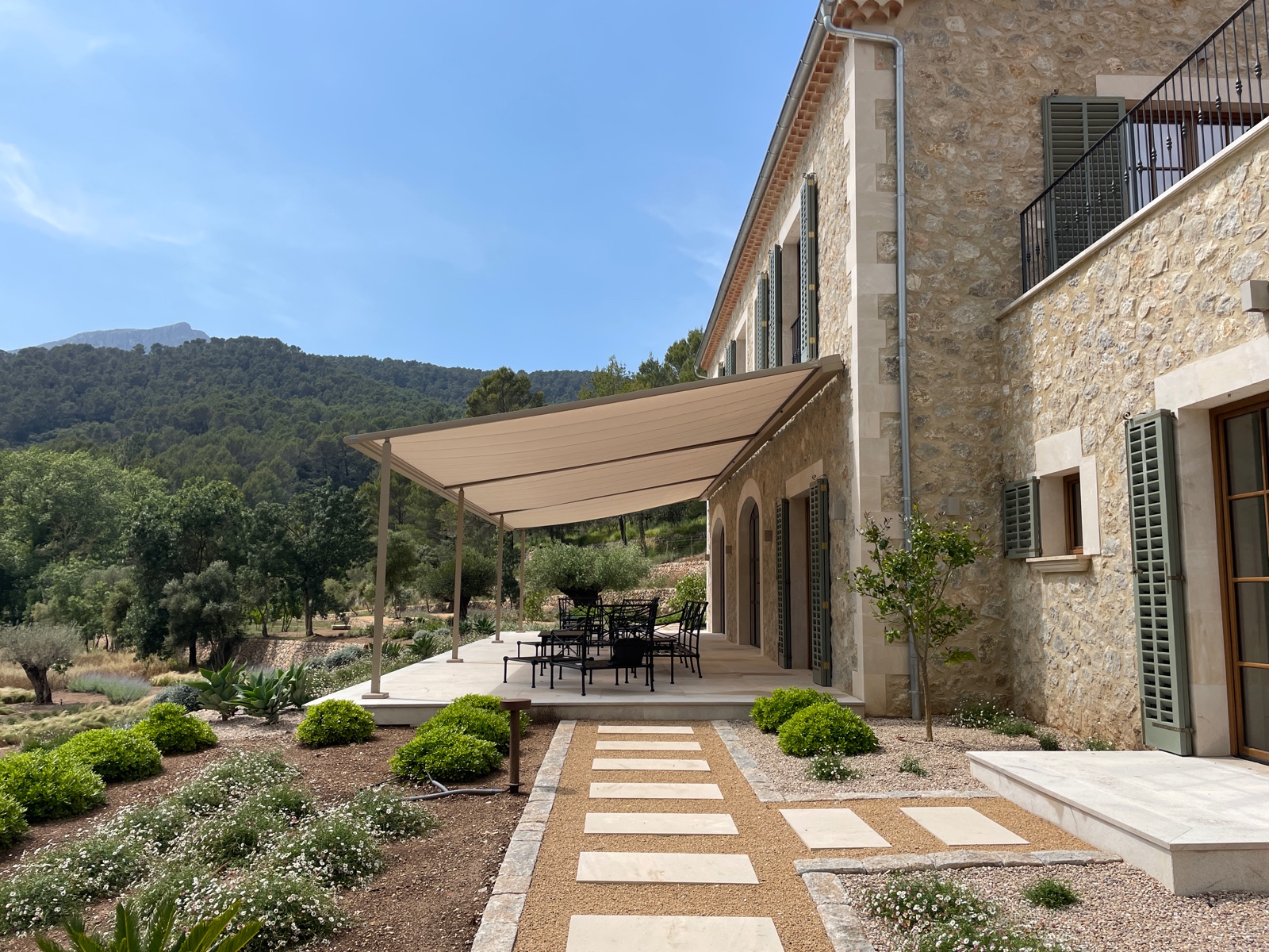 Toldo pérgola sobre terraza de casa de piedra