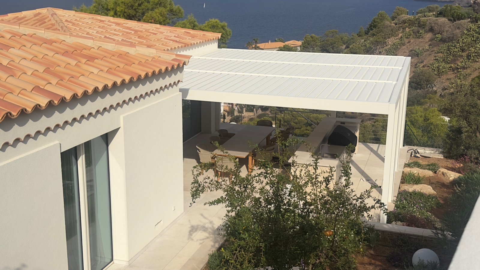 Pérgola bioclimática blanca sobre terraza con vistas