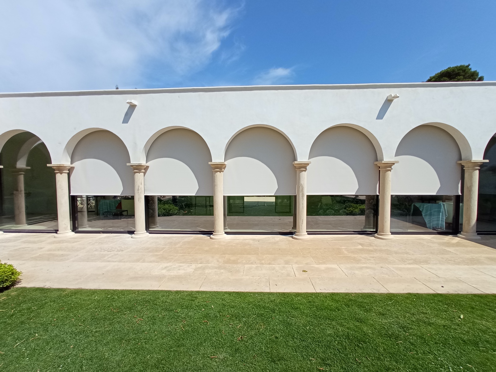 Estores exteriores en fachada con arcos y columnas