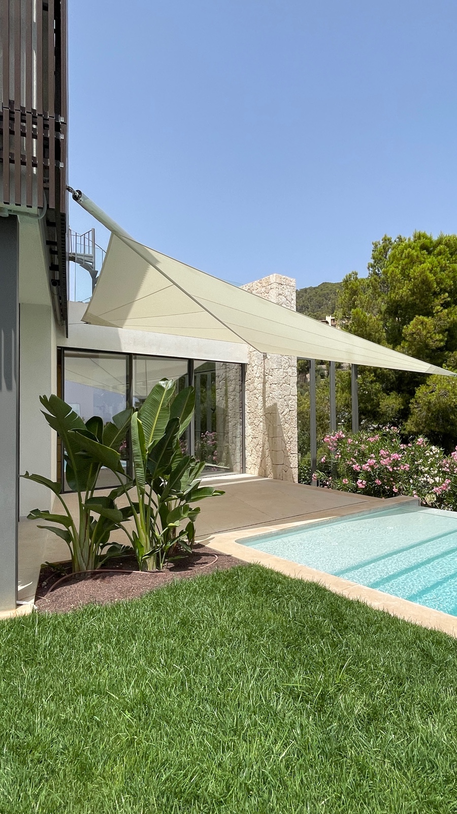 Vela tensada sobre piscina en villa moderna