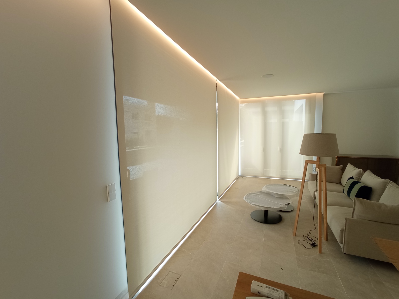 Estor enrollable beige en salón con LED perimetral