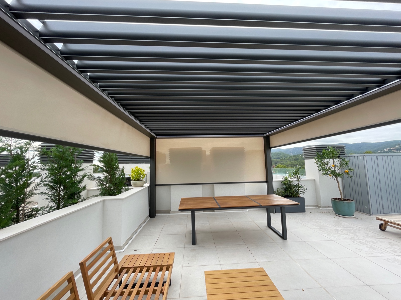 Pérgola bioclimática oscura con cortinas verticales